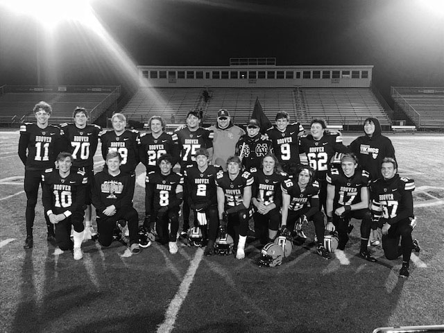 The+senior+boys+football+team+poses+with+Coach+Baum+after+a+game.+