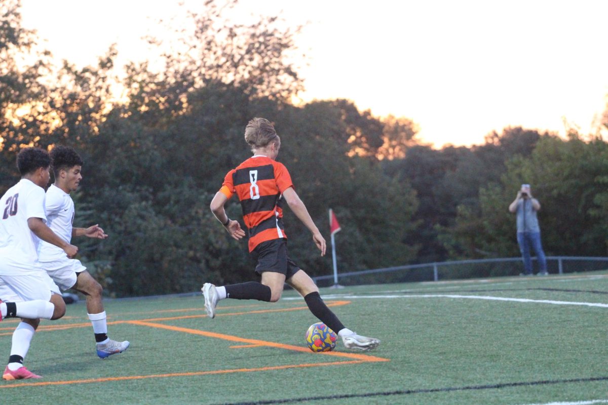 Senior Cameron VanNatta strikes the ball as he runs towards the goal on senior night against McKinley.