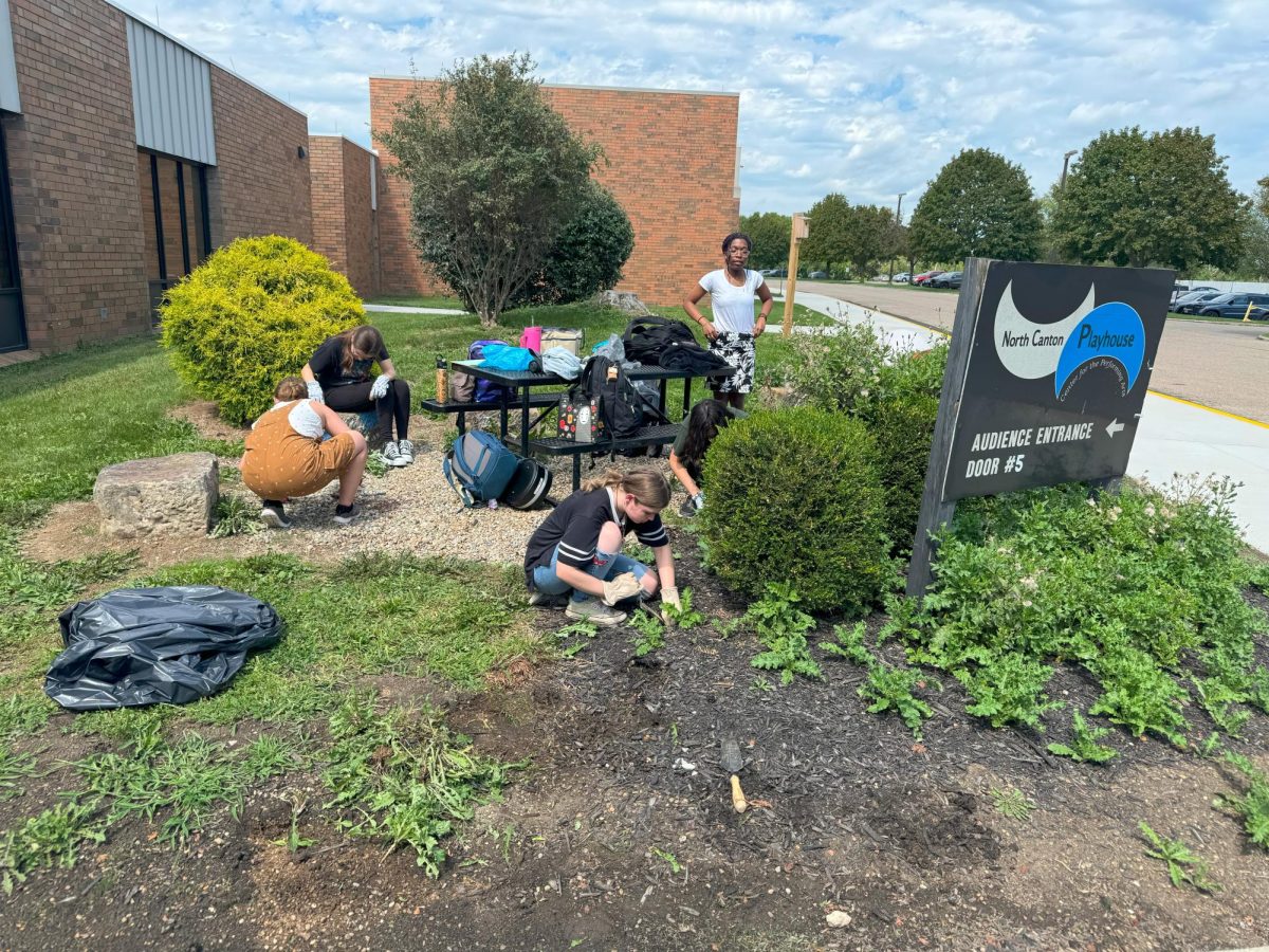 The Garden Club works on the flowerbed by the North Canton Playhouse Entrance