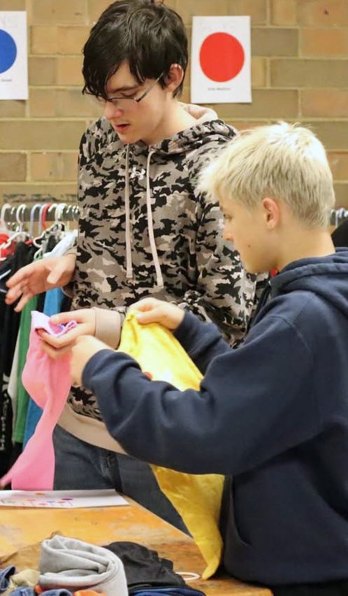 NCMS eighth graders Phillip Ogilvie and Costas Paxos, members of the National Junior Honor Society, packed summer clothing for those in need. They and other NJHS members decorated the CARE Team Santa's Closet during November