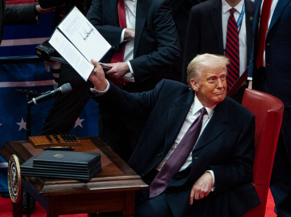 U.S. President Donald Trump shows off an executive order he signed at an indoor Presidential Inauguration parade event at the Capital One Arena. 