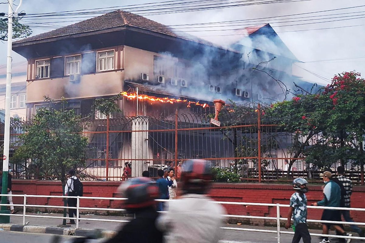 n People walk past a fire 
in the Supreme Court building in Kathmandu on Sept. 9, 2025, a day after a police crackdown on demonstrations over social media prohibitions and corruption by 
the government. Nepali youth protesters set fire to parliament on September 9 as the veteran prime minister obeyed furious crowds to quit, a day after one of the 
deadliest crackdowns in years in which at least 19 people were killed