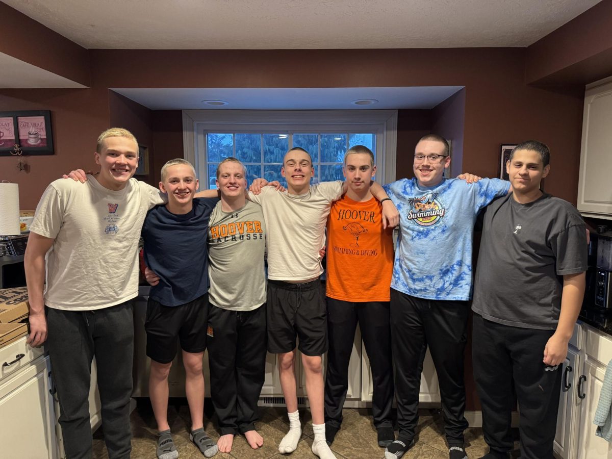 The Hoover boys swim team poses for photo after shaving their heads  Feb. 16 in support of St. Baldricks. This donation goes towards a charity that invests in childhood cancer research.